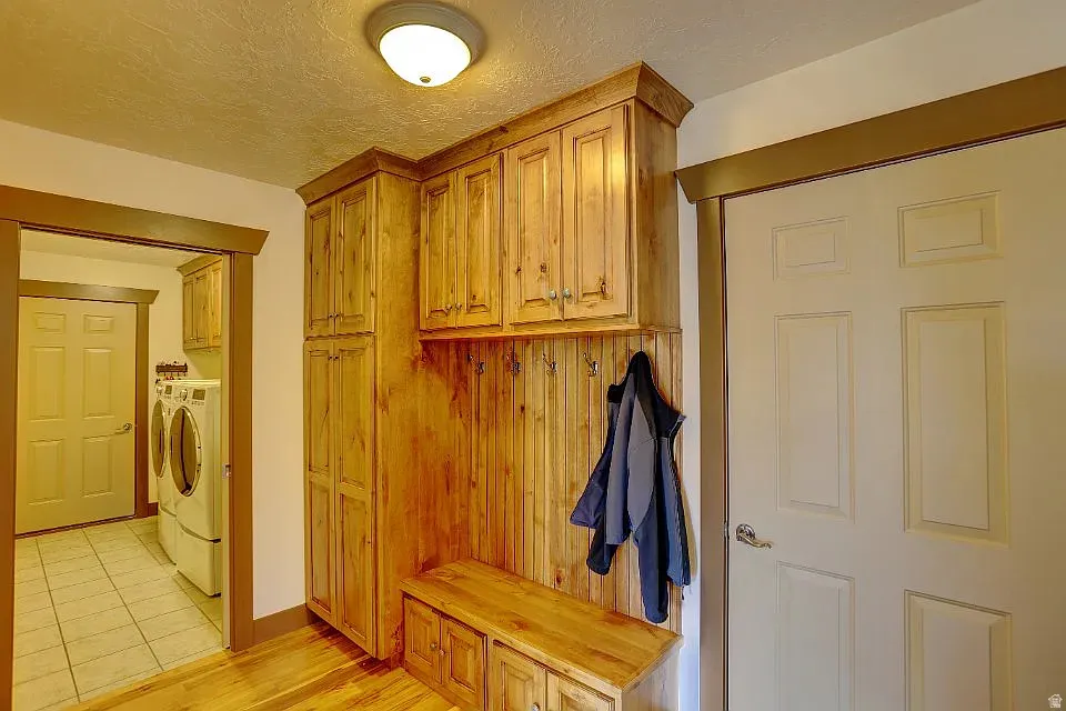 Custom wood-finish cabinetry featuring integrated bench seating and coat hooks