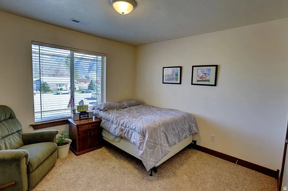 Room featuring a large window with horizontal blinds and a wood-finish sill