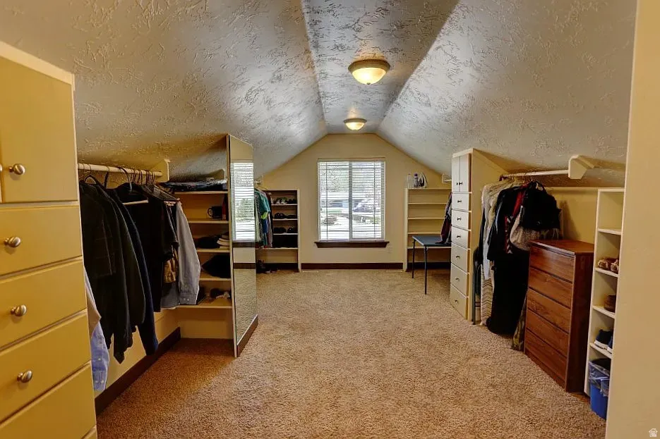 Spacious attic room with sloped ceilings and recessed lighting