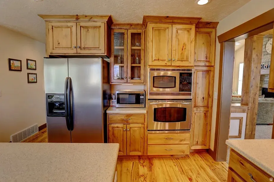 Kitchen featuring wood-finish cabinetry, stainless steel appliances, and light-toned countertops