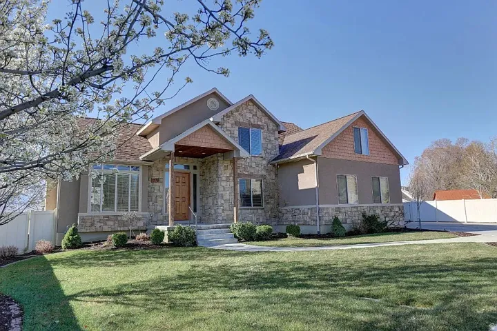 Stone and stucco exterior with an accent wood-paneled gable