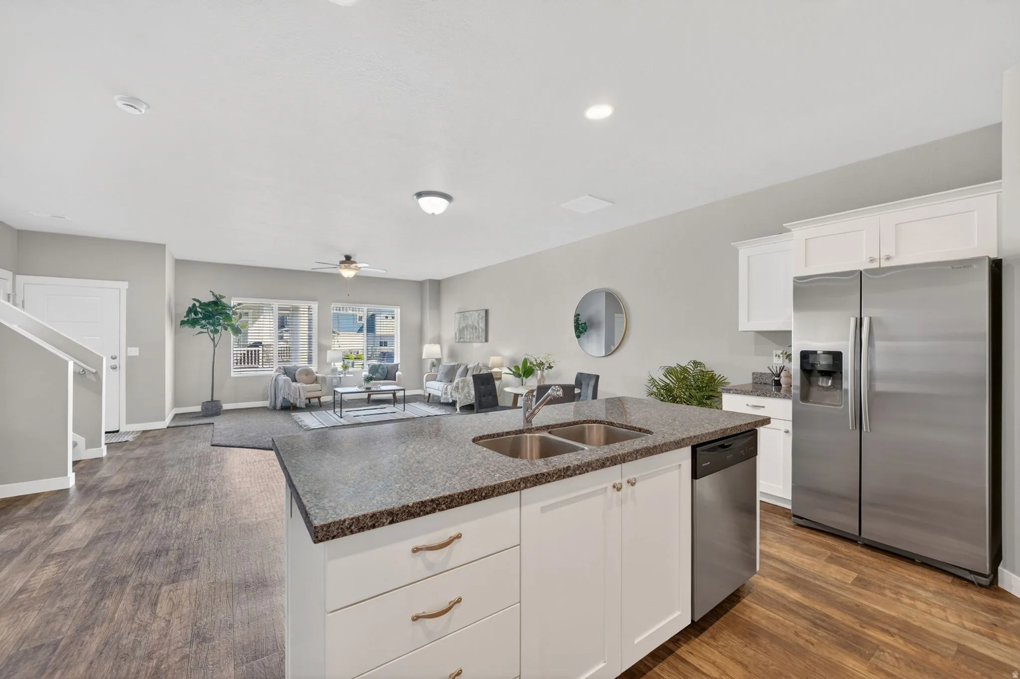 Kitchen island with a double basin stainless steel sink and dark speckled countertop