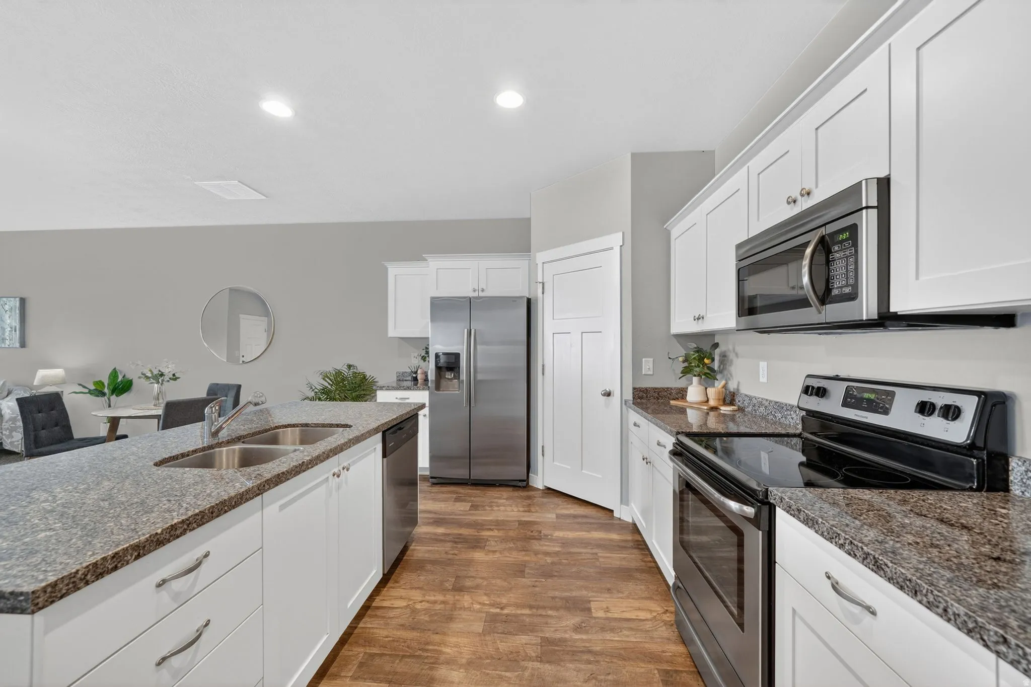Kitchen with wood-finish flooring and white cabinetry