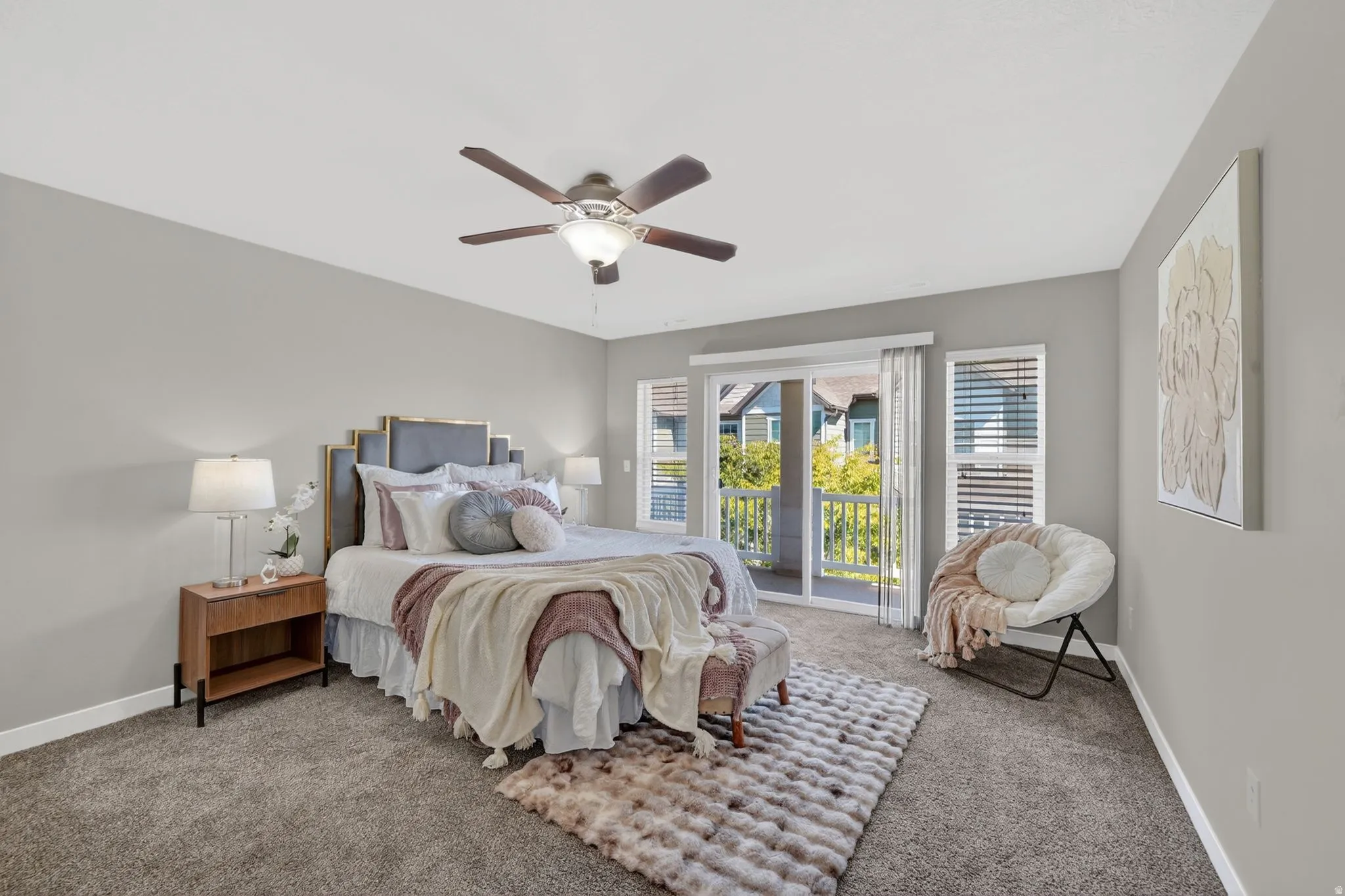 Spacious room featuring neutral carpeting, a ceiling fan with integrated lighting, and light gray wall tones
