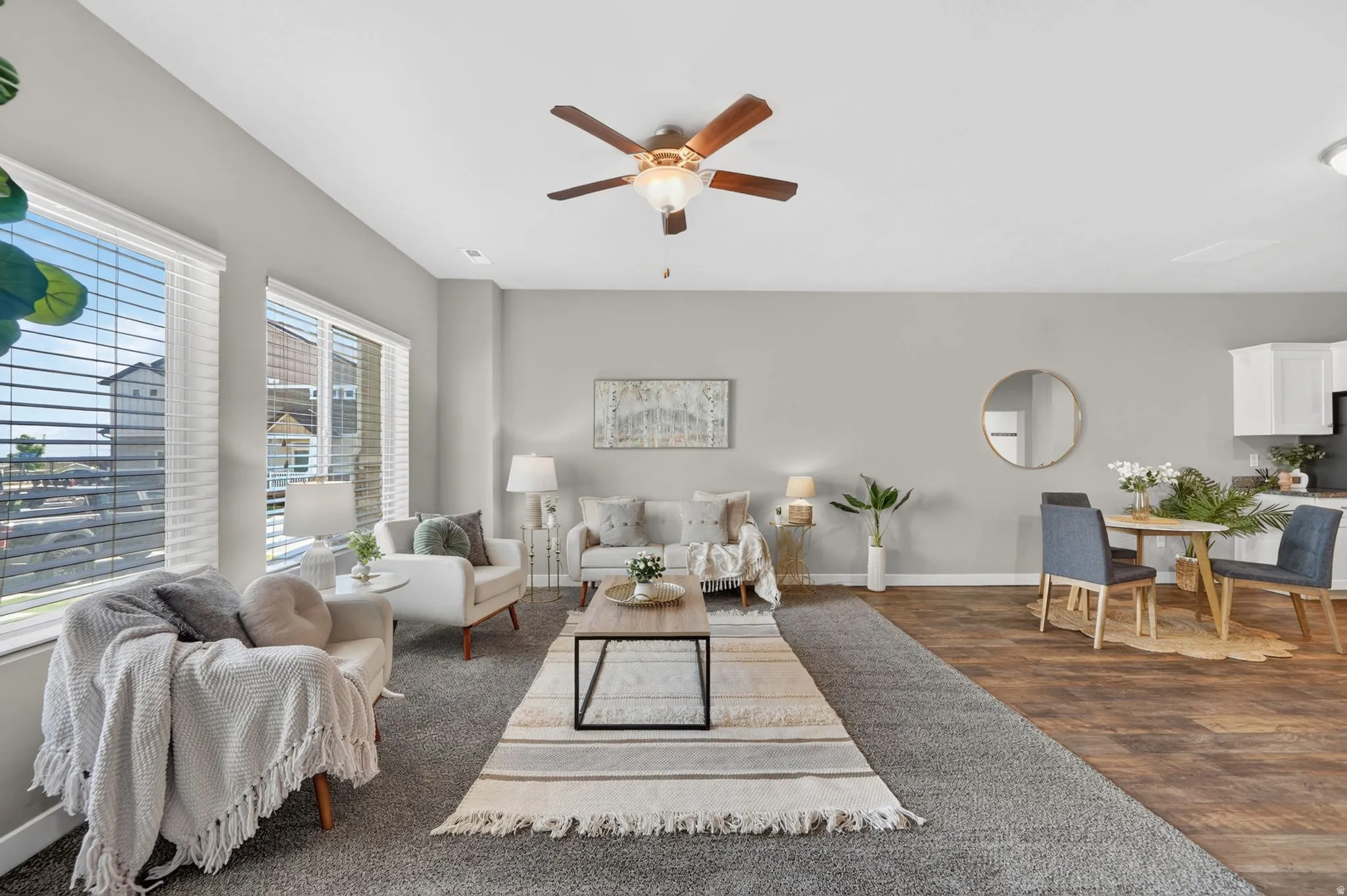 Open-concept living area featuring a ceiling fan, large windows with blinds, and recessed lighting