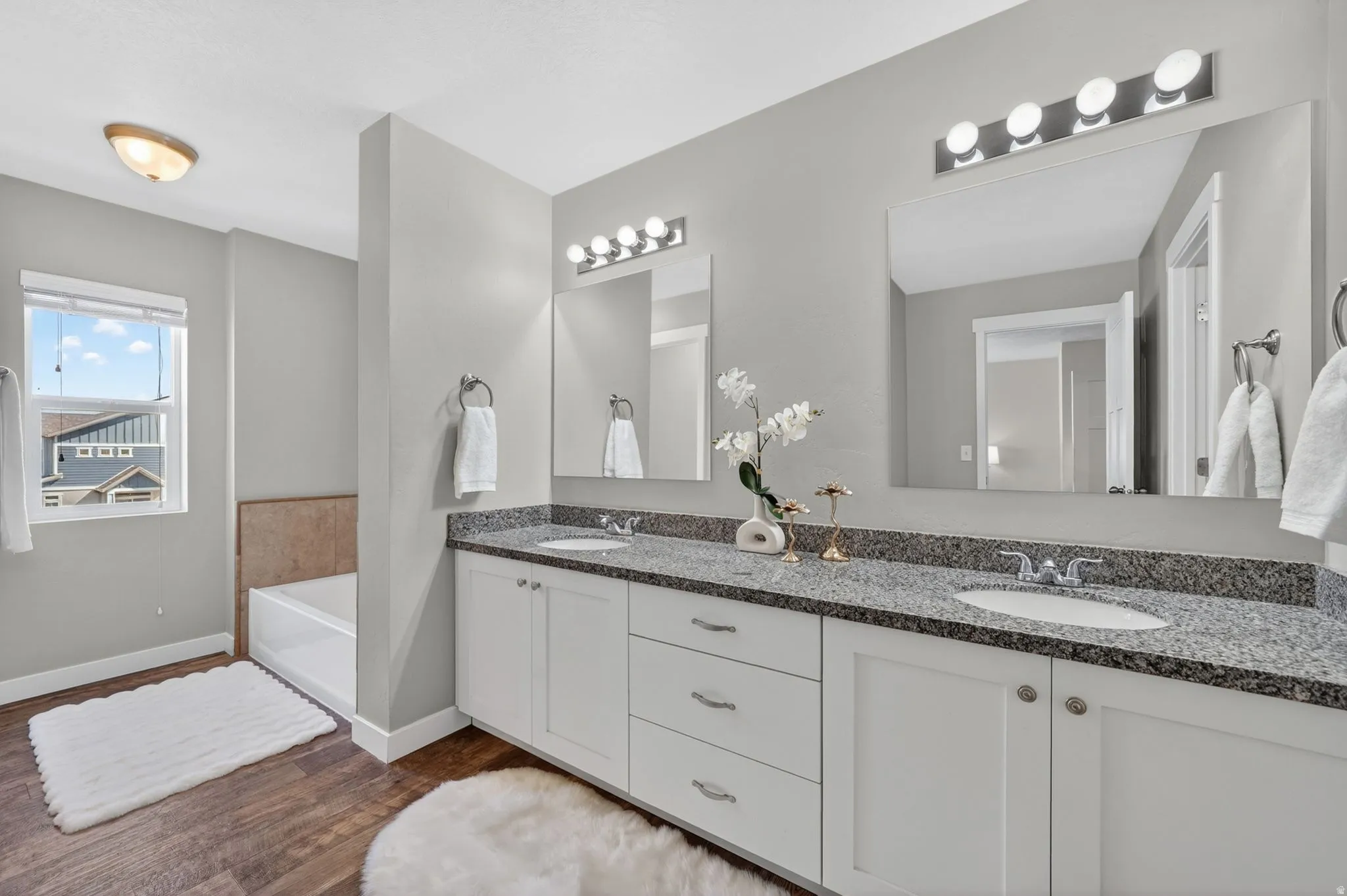Double vanity with white cabinetry and granite-finish countertops