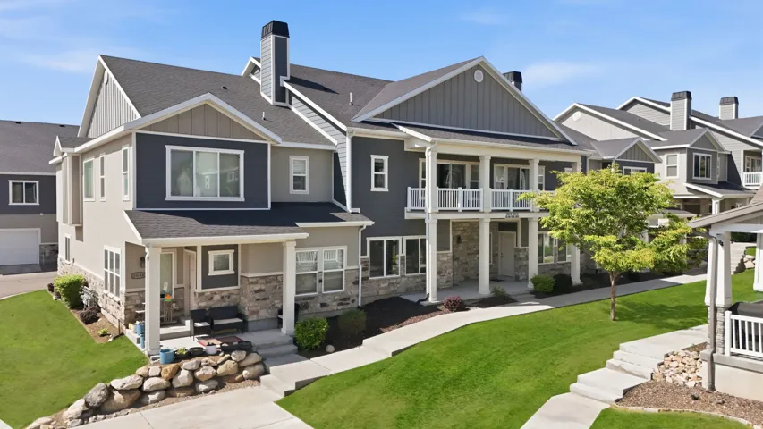 Contemporary townhome exterior featuring multi-toned siding, stone accents, and dark shingle roofing