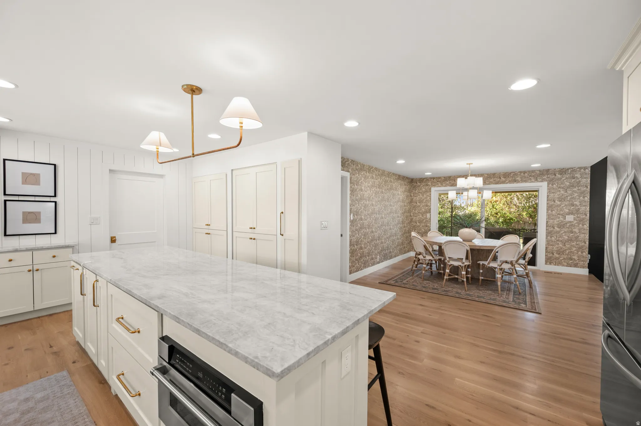 Kitchen island with a light-toned stone countertop, integrated microwave, and brass hardware