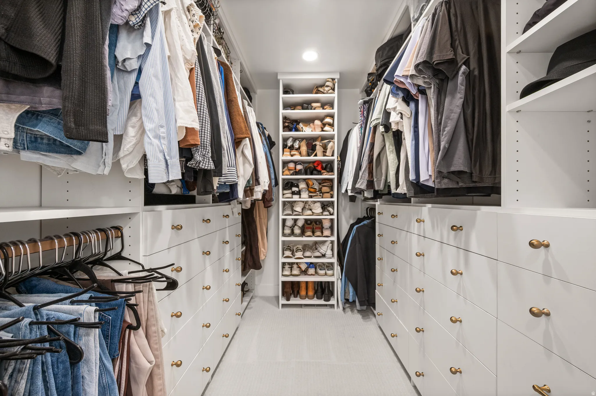 Custom walk-in closet featuring built-in cabinetry, integrated shelving, hanging rods, recessed lighting, and a dedicated shoe rack