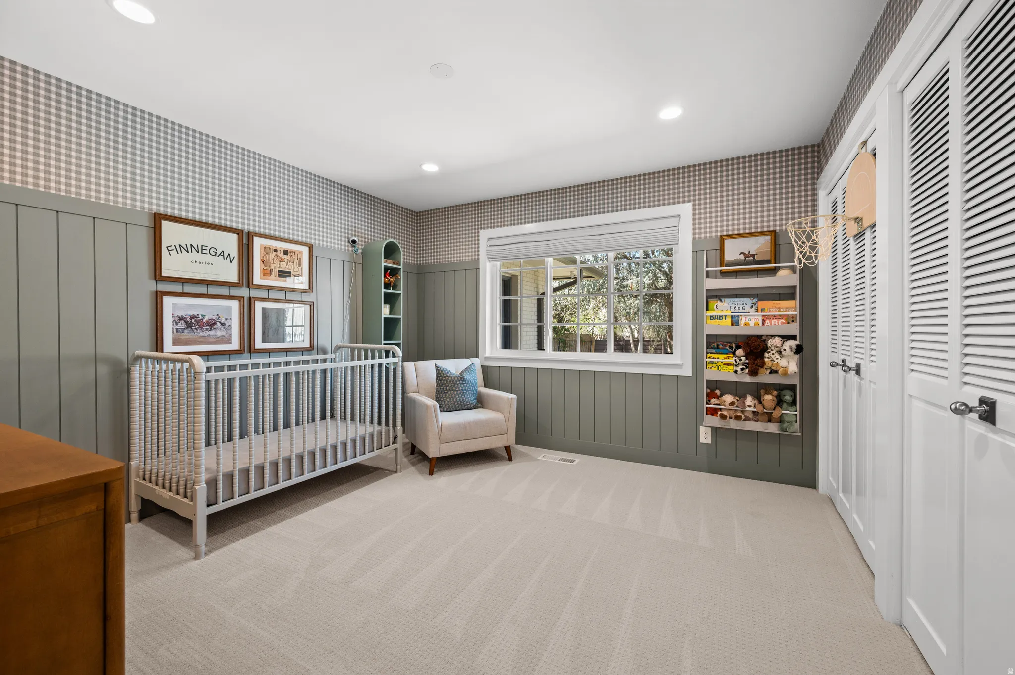 Inviting room featuring a broad window, recessed lighting, wall paneling, and a neutral carpet