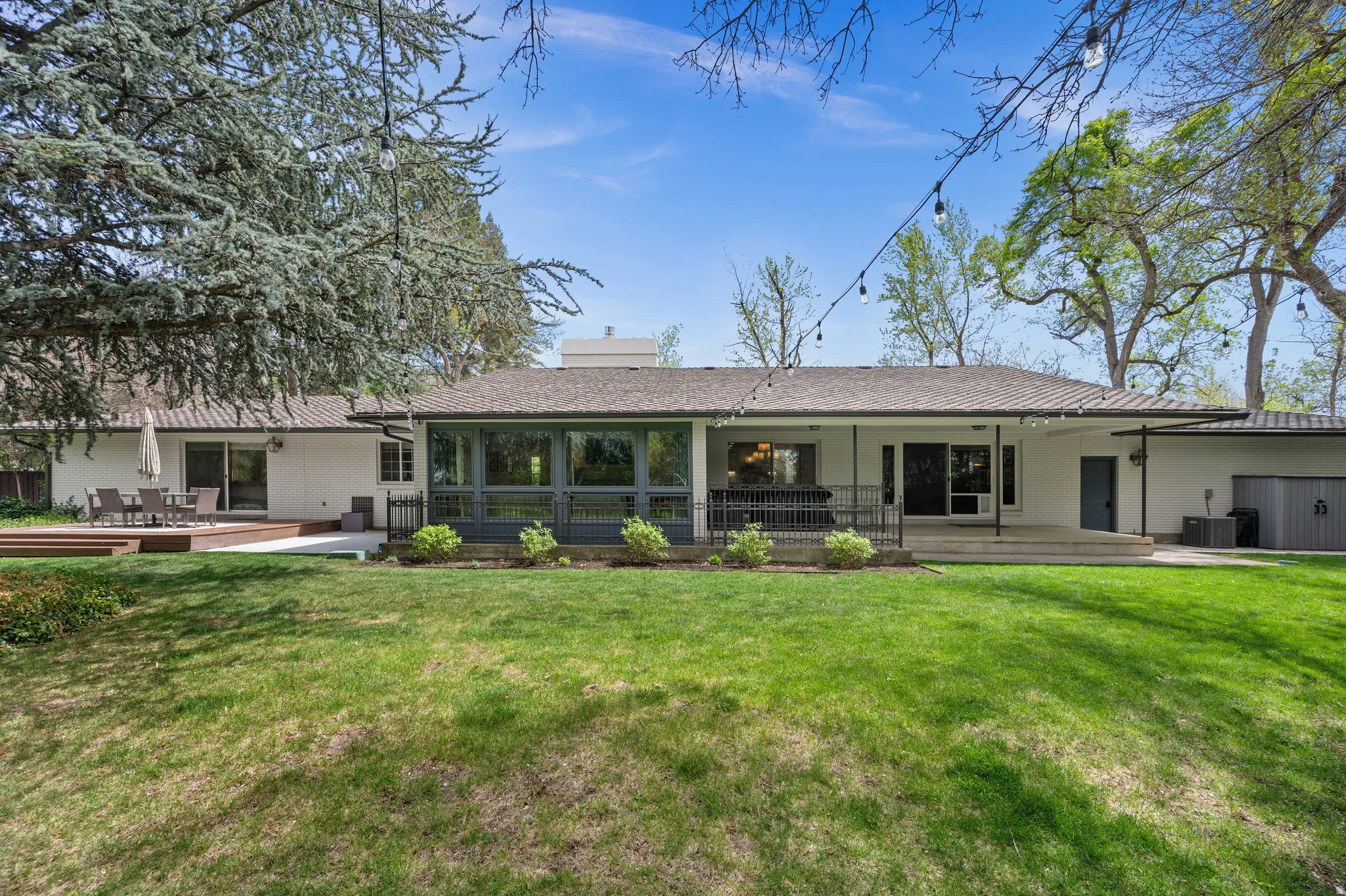 Expansive lawn with a wood-finish deck and concrete patio areas