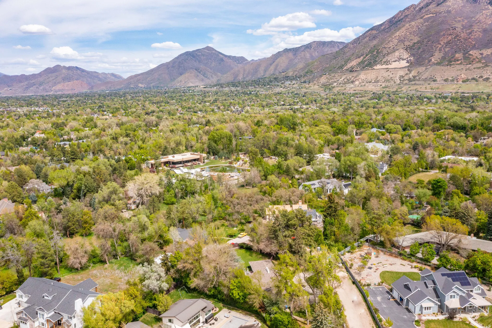 Expansive residential area featuring mature tree coverage, mountain backdrops, and varied architectural styles