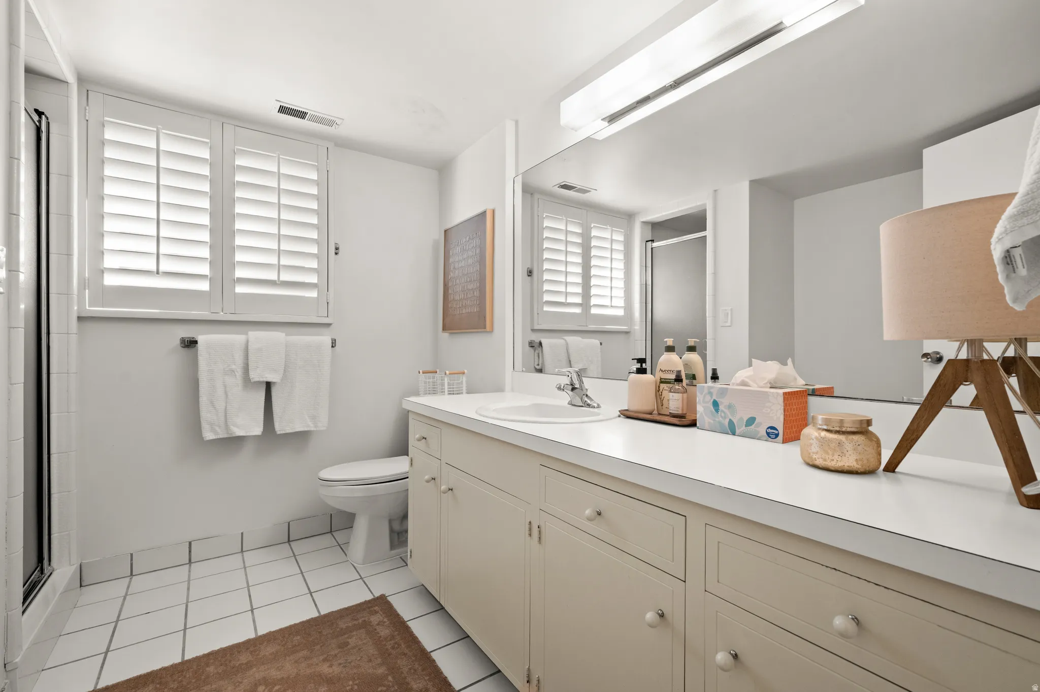 Bathroom featuring a vanity with an integrated sink, a rectangular mirror, and an overhead light fixture