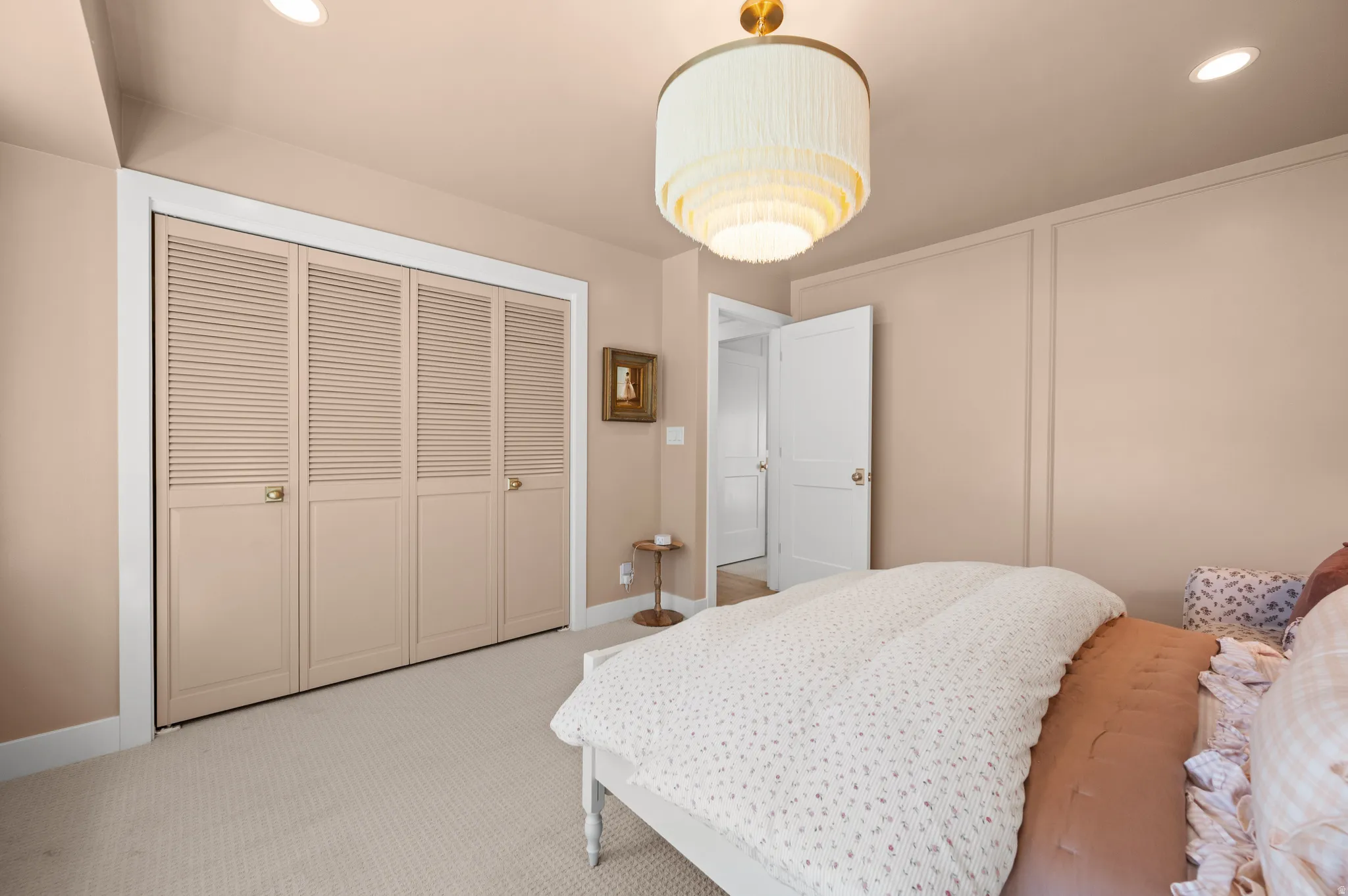 Bedroom featuring light-colored carpet flooring, recessed lighting, and a decorative ceiling fixture