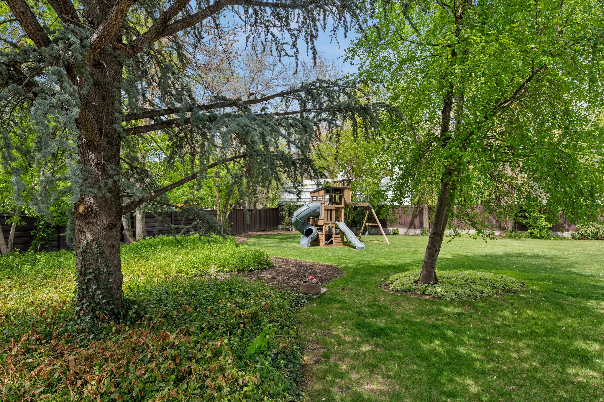 Expansive green lawn with mature trees and established groundcover