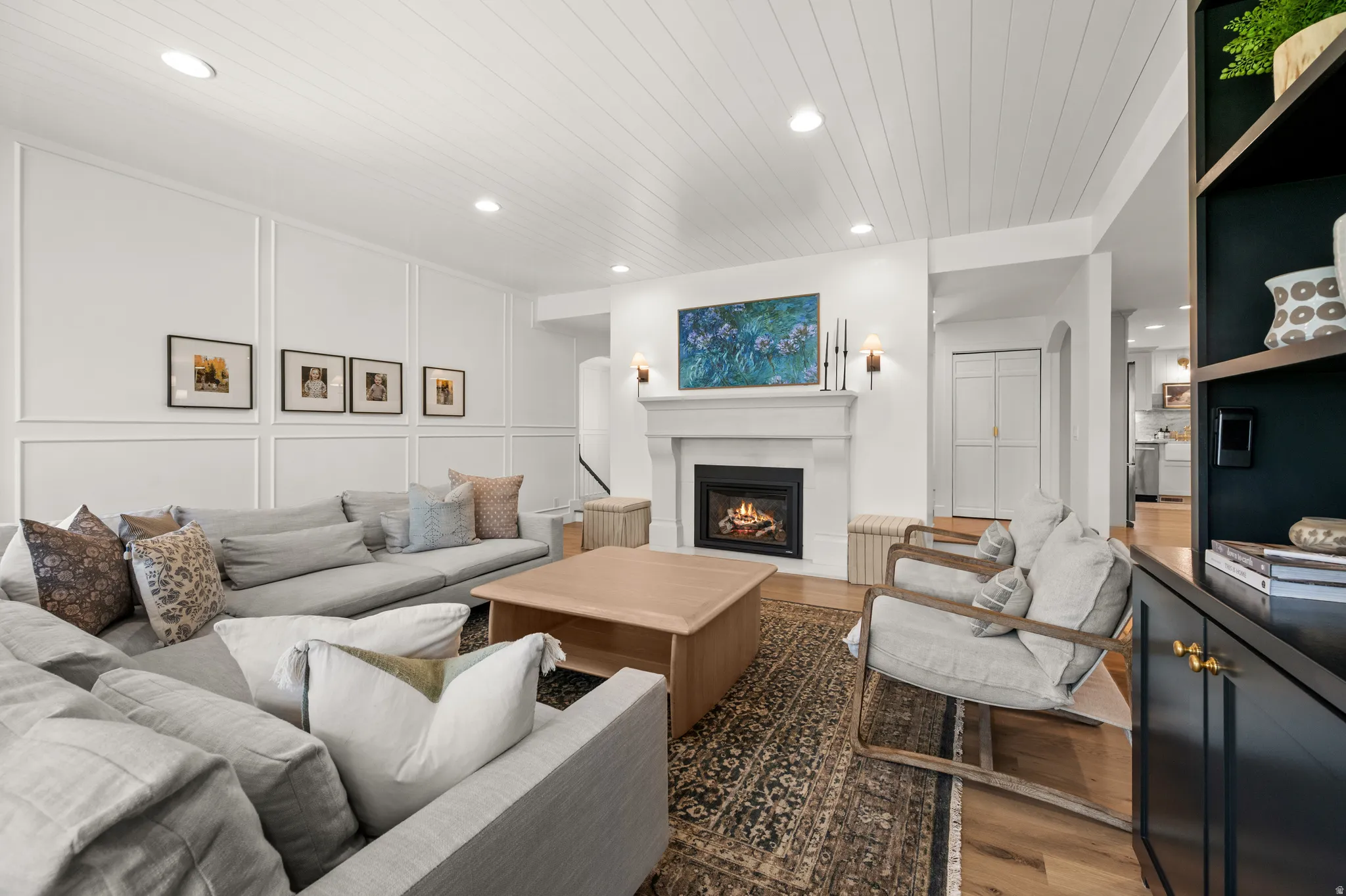 Living area featuring a fireplace with a white mantel, recessed lighting, and wood-finish flooring