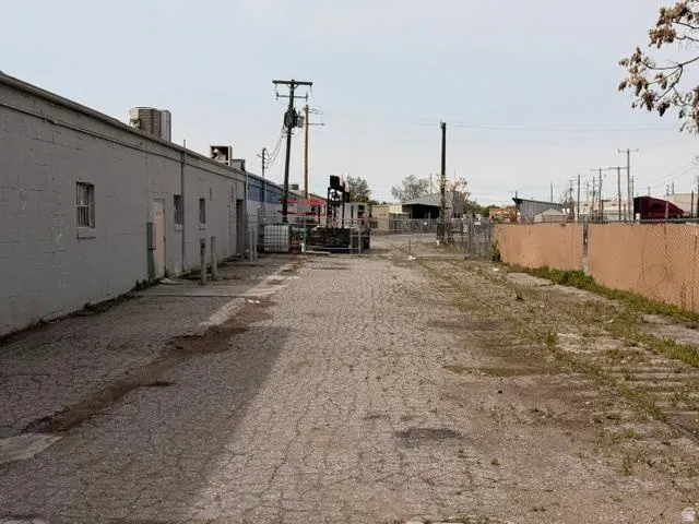 Paved lot with perimeter fencing and industrial building