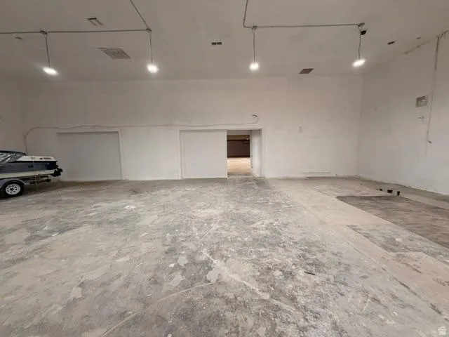 Expansive open-concept room featuring concrete flooring and white walls