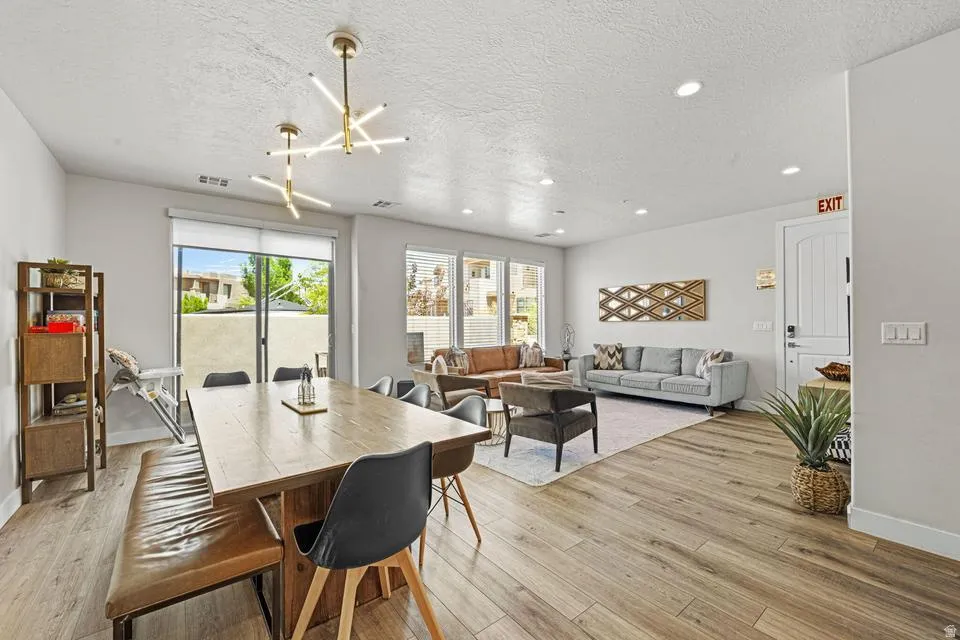 Open-concept interior featuring wood-finish flooring, recessed lighting, and a sliding glass door leading to the exterior