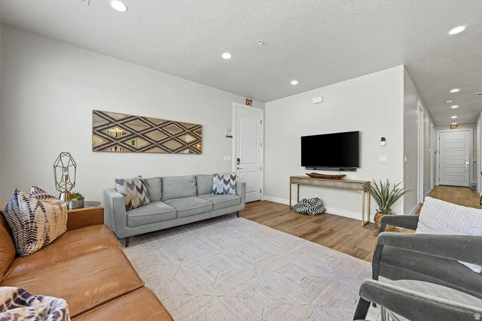Open-concept living space featuring wood-finish flooring, recessed lighting, and a neutral color palette