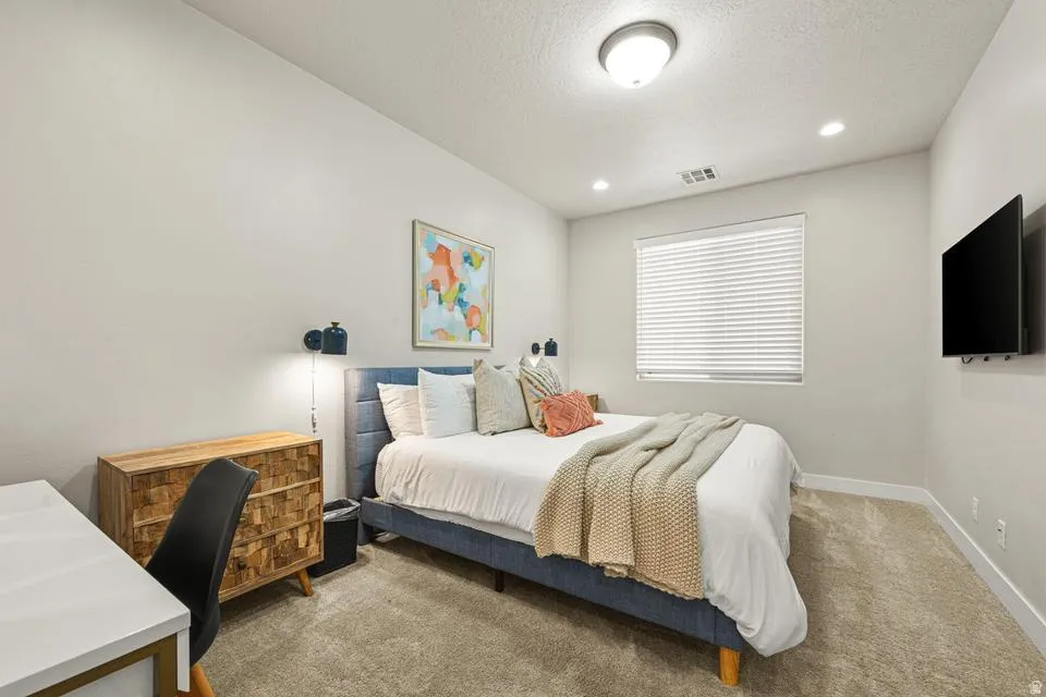 Neutral tone walls complemented by recessed lighting and a ceiling-mounted fixture