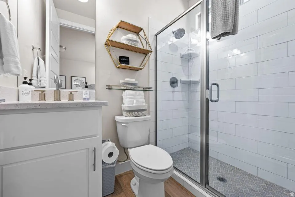 Modern bathroom featuring a glass-enclosed shower with subway tile surround and mosaic floor