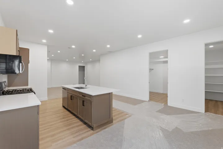 Modern kitchen featuring an island with an undermount sink and a gas range