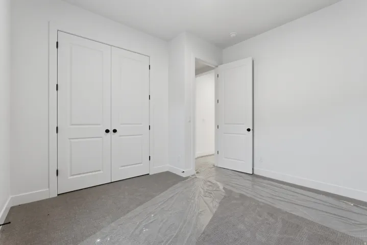 Room featuring a closet with bi-fold paneled doors and matte black hardware
