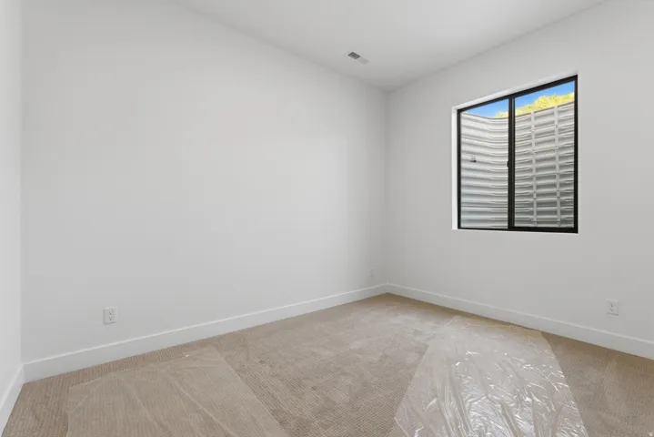 Neutral tone room featuring carpet flooring and white baseboards
