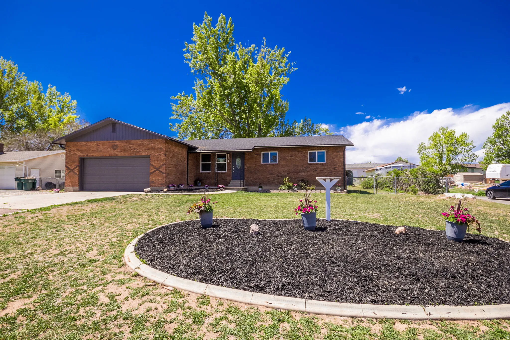 Brick ranch-style residence featuring an attached garage with an automatic door