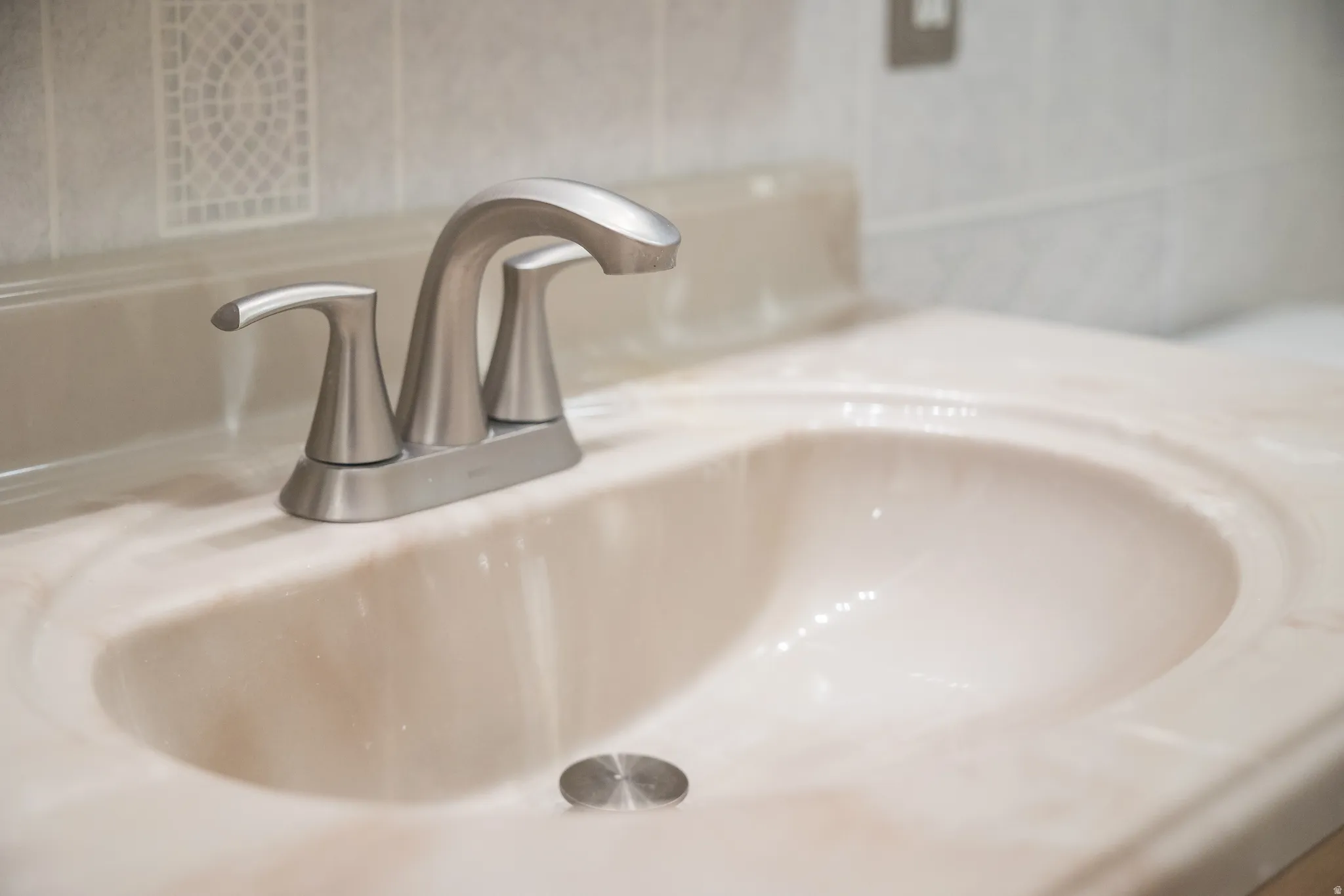 Integrated vanity sink with brushed nickel faucet