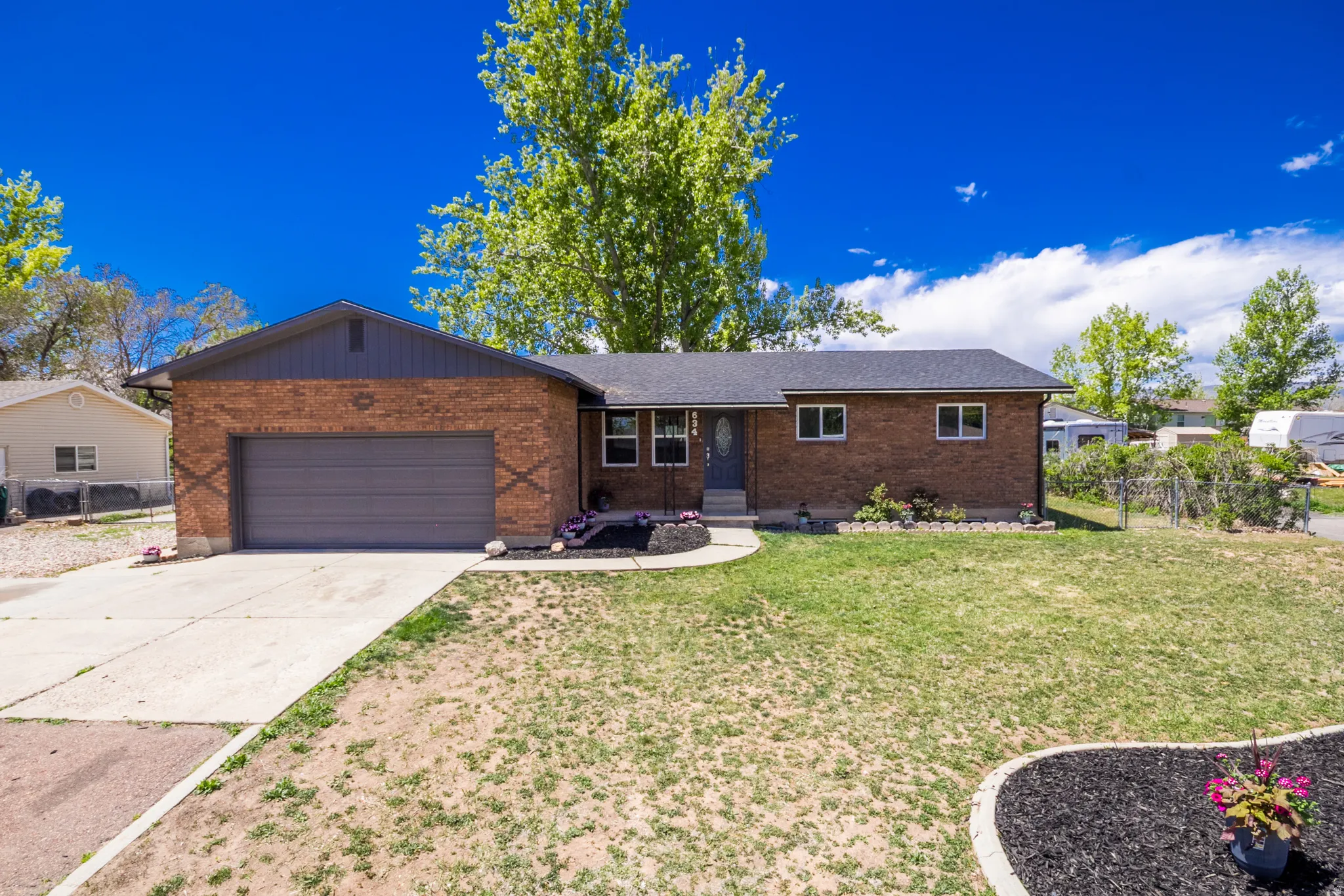 Brick exterior with a dark shingle roof and an integrated garage