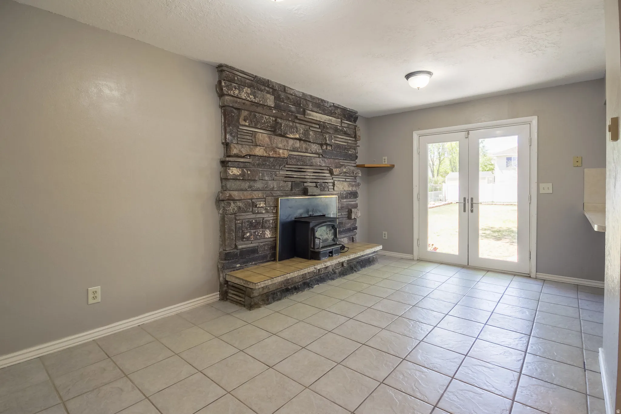 Stone-clad fireplace with a wood-burning stove and a tiled hearth
