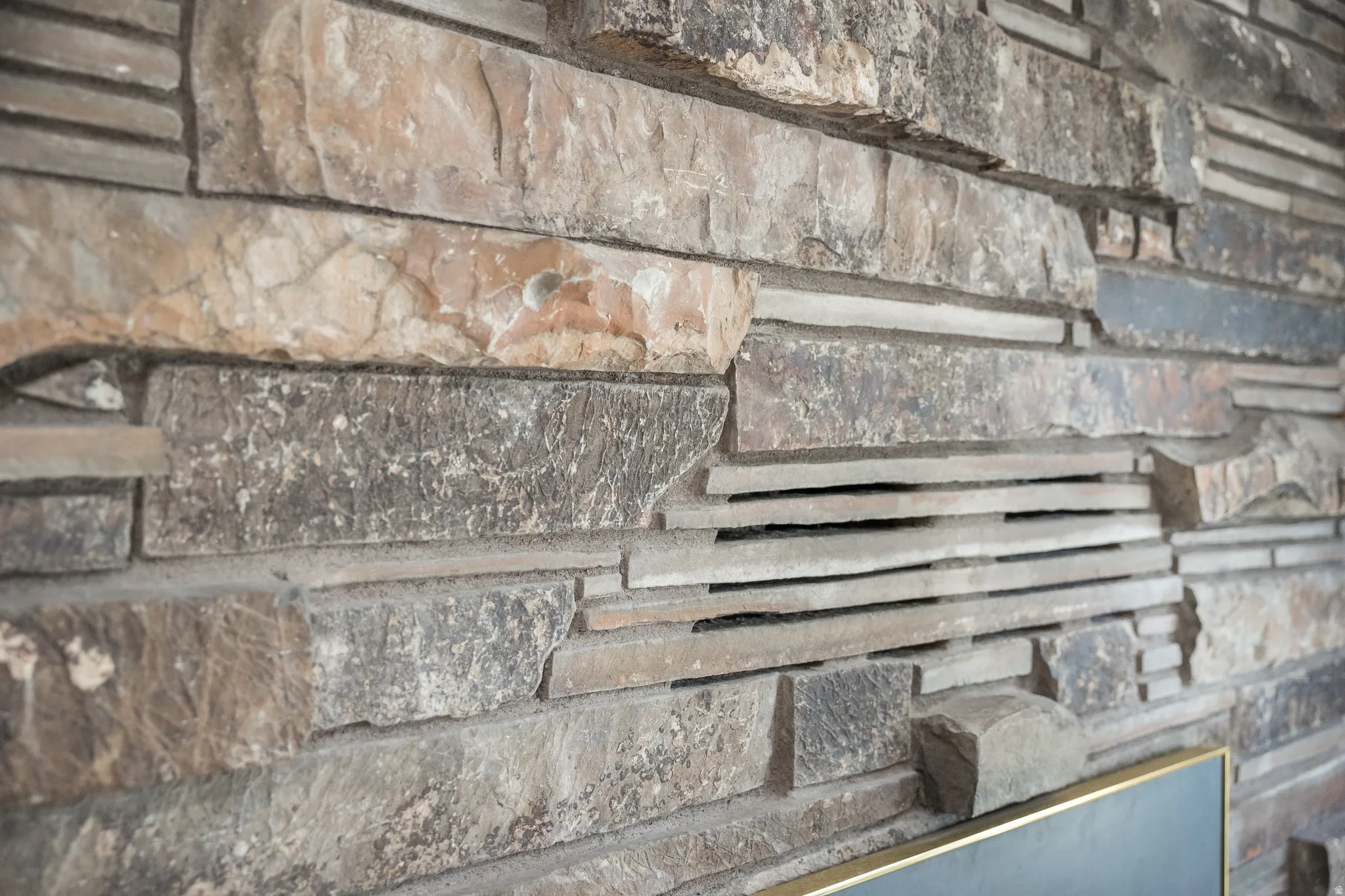 Textured stone wall featuring varied cuts and natural hues