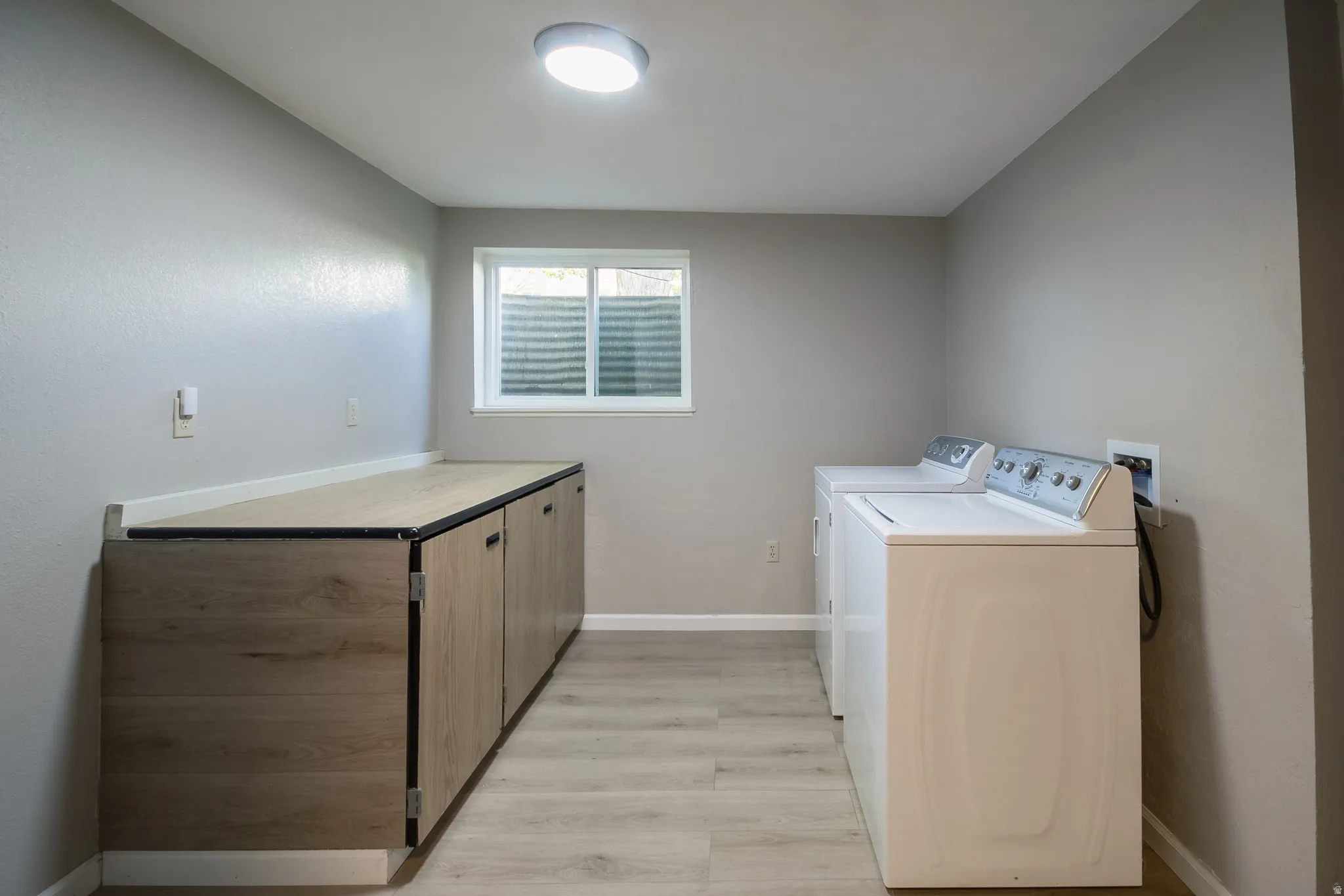 Utility area featuring wood-finish flooring and light gray painted walls
