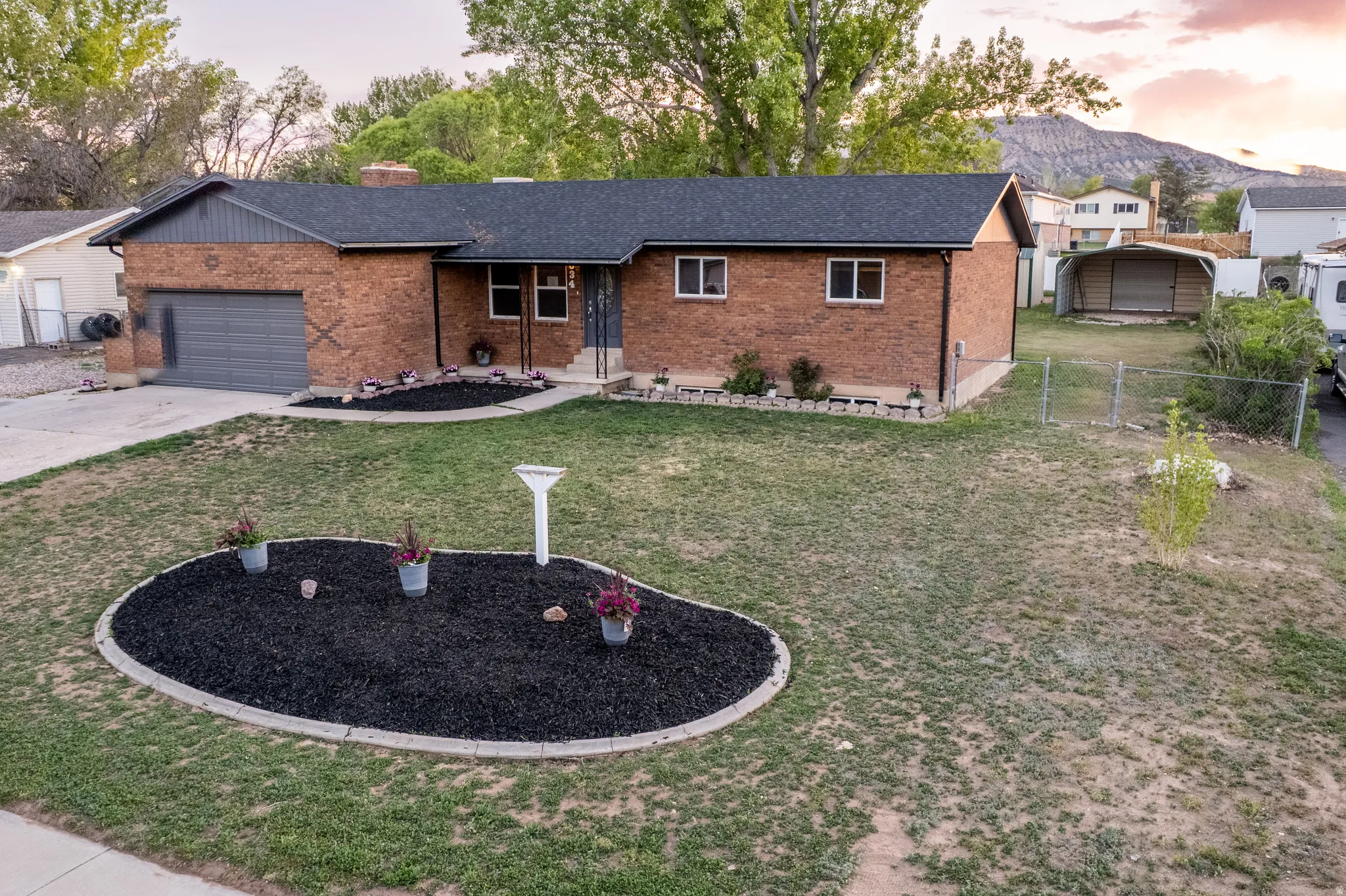 Brick exterior with a dark shingle roof and an attached garage