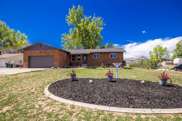 Brick ranch-style residence featuring an attached garage with an automatic door
