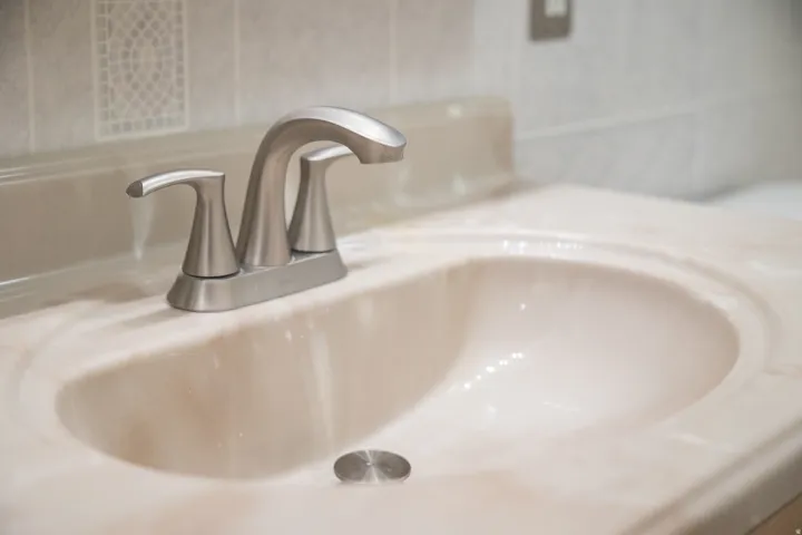 Integrated vanity sink with brushed nickel faucet