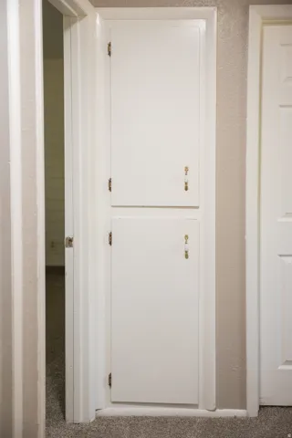 Built-in cabinetry with two white panel doors and decorative brass hardware