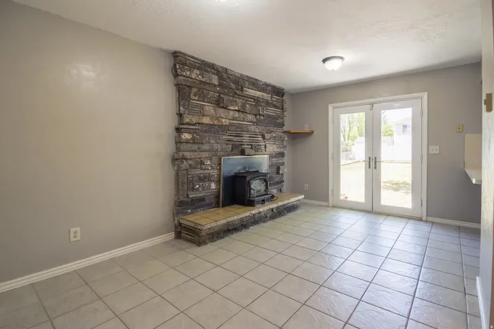 Stone-clad fireplace with a wood-burning stove and a tiled hearth