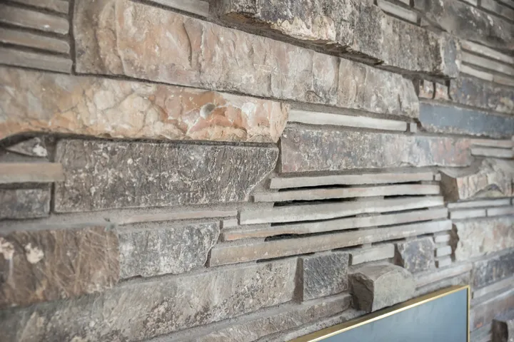 Textured stone wall featuring varied cuts and natural hues