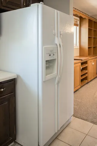 White side-by-side refrigerator with integrated ice and water dispenser