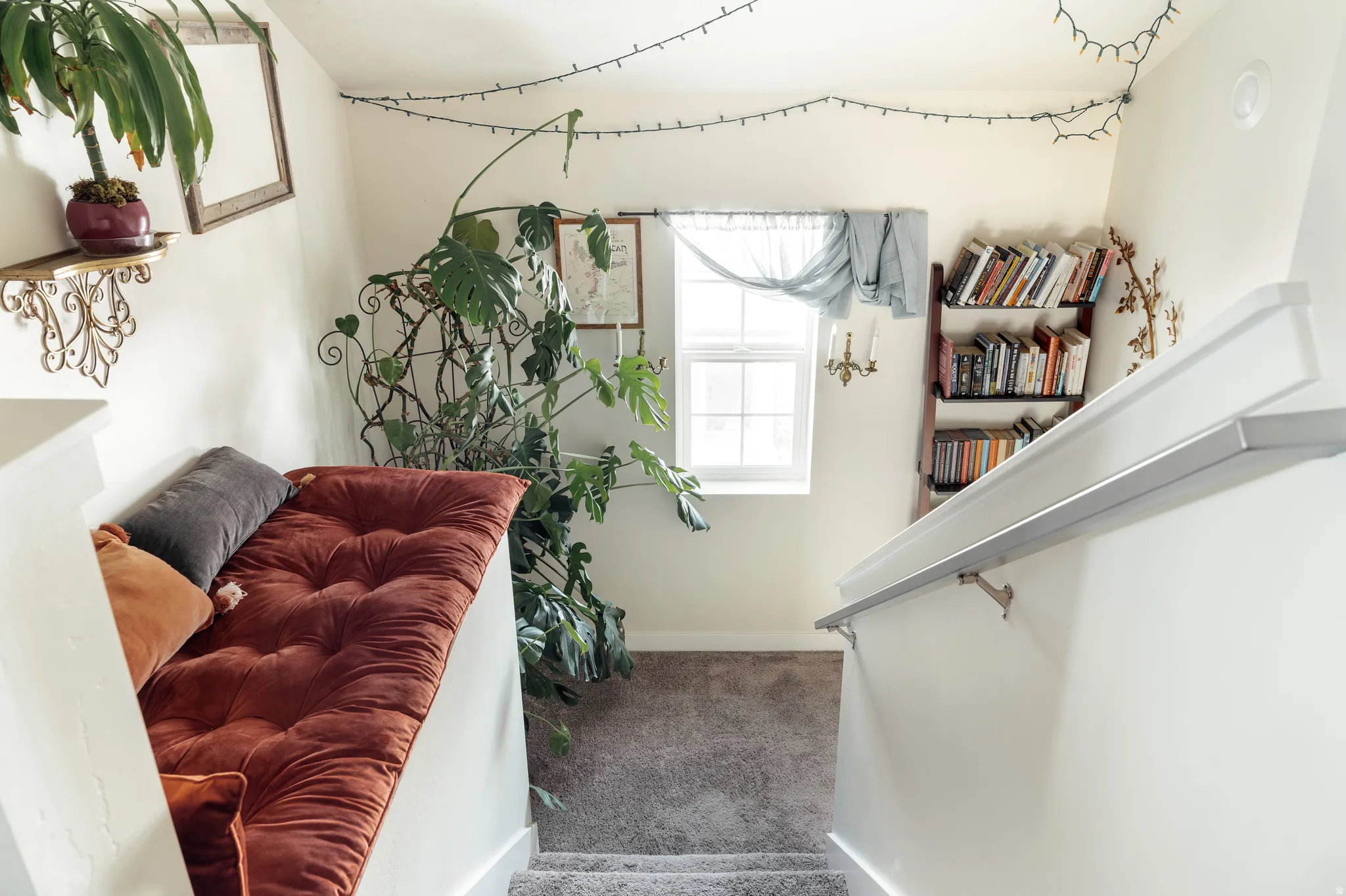 Carpeted staircase with white walls and a light gray handrail