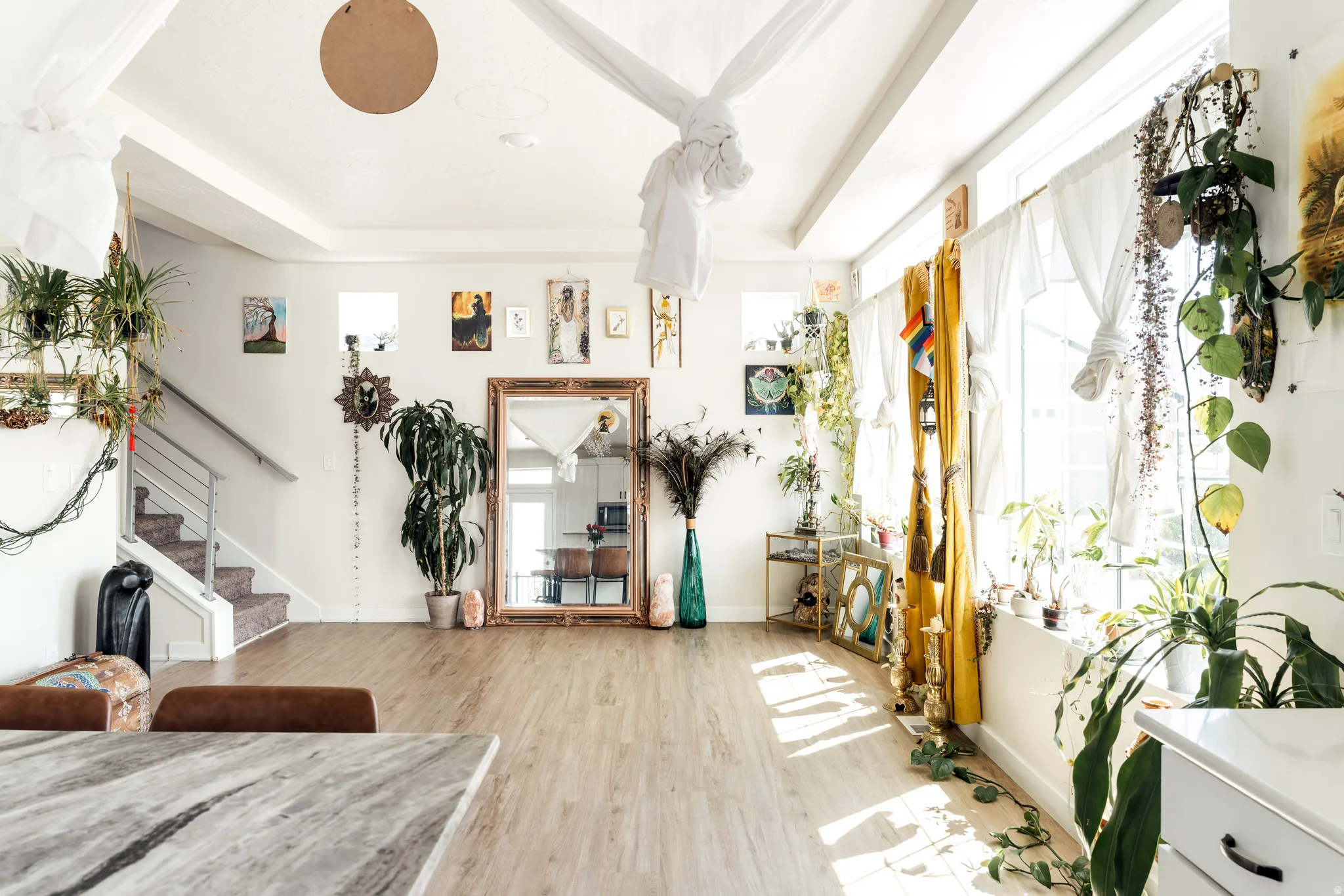 Spacious room featuring wood-finish flooring, high ceilings with exposed beams, and multiple windows for abundant illumination
