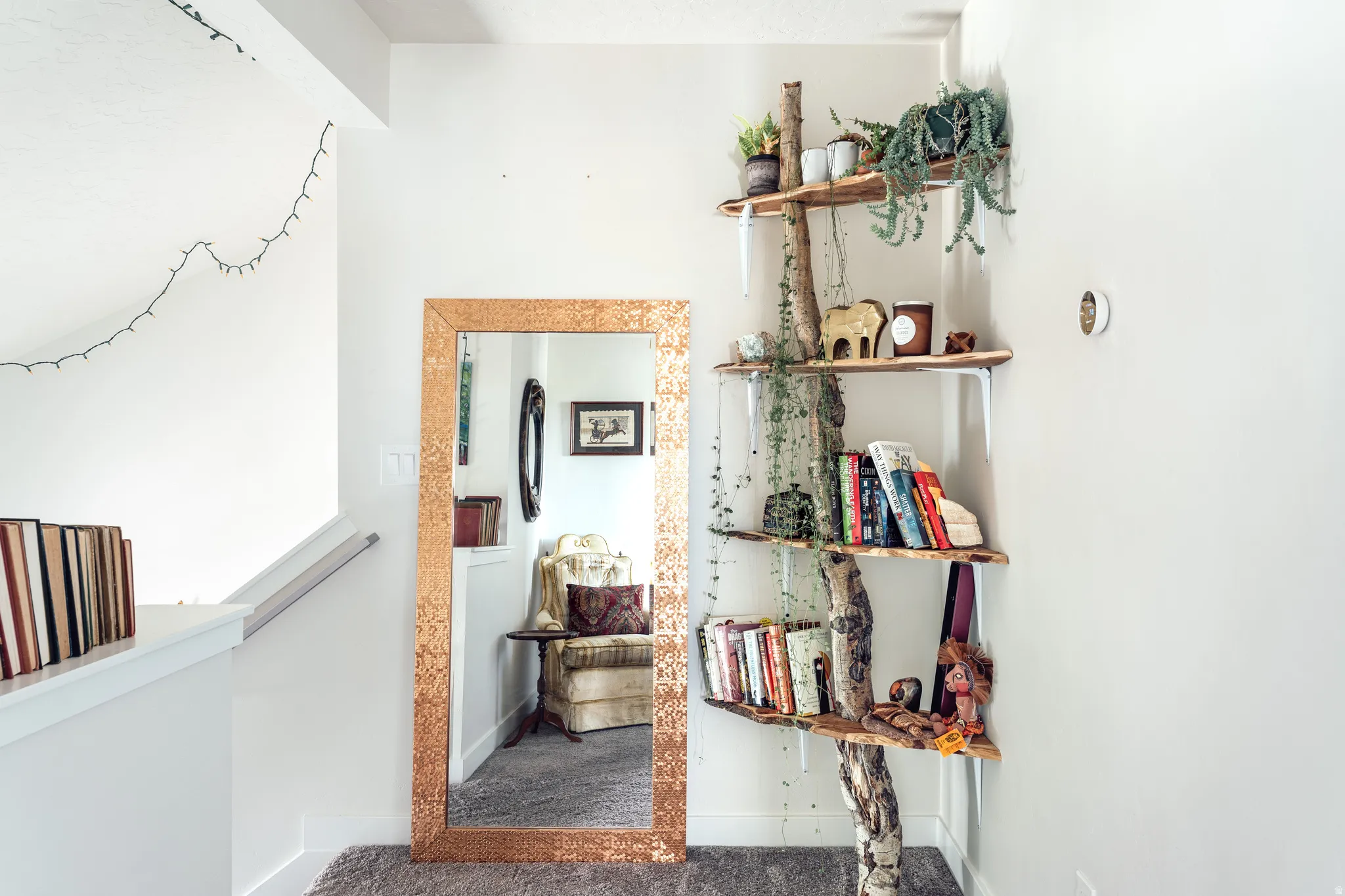 White wall finishes create an expansive feel in this hallway, complemented by plush carpeting and a modern built-in wall thermostat