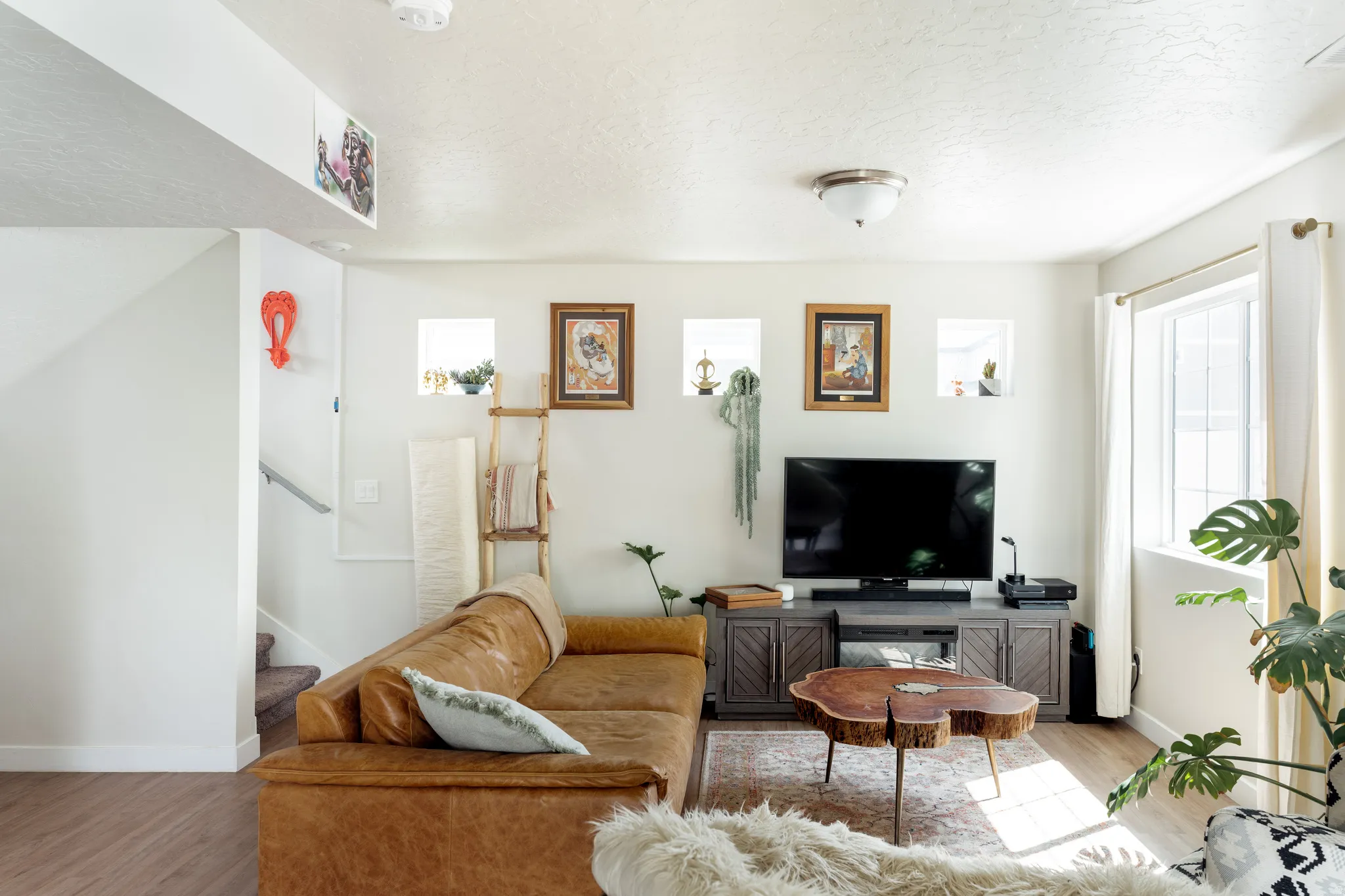 Living area featuring wood-finish flooring, white walls, and a recessed wall niche