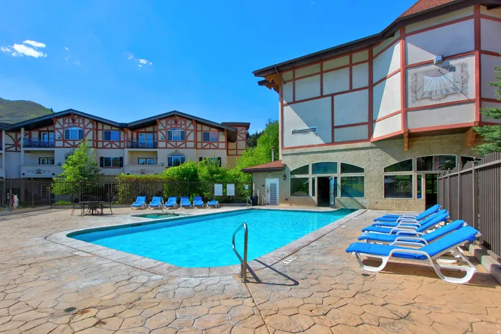 Outdoor swimming pool with integrated spa, surrounded by textured concrete decking