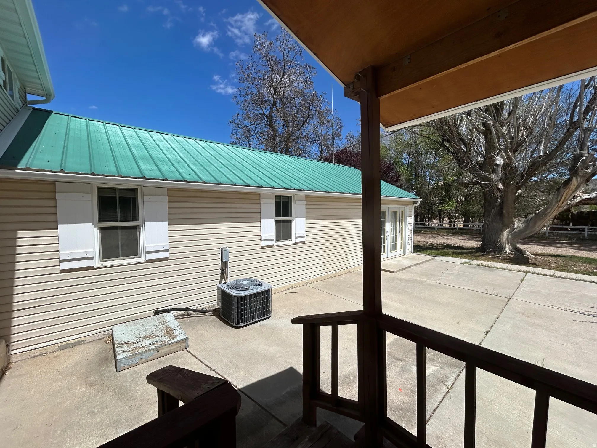 Expansive concrete patio area with a covered porch section