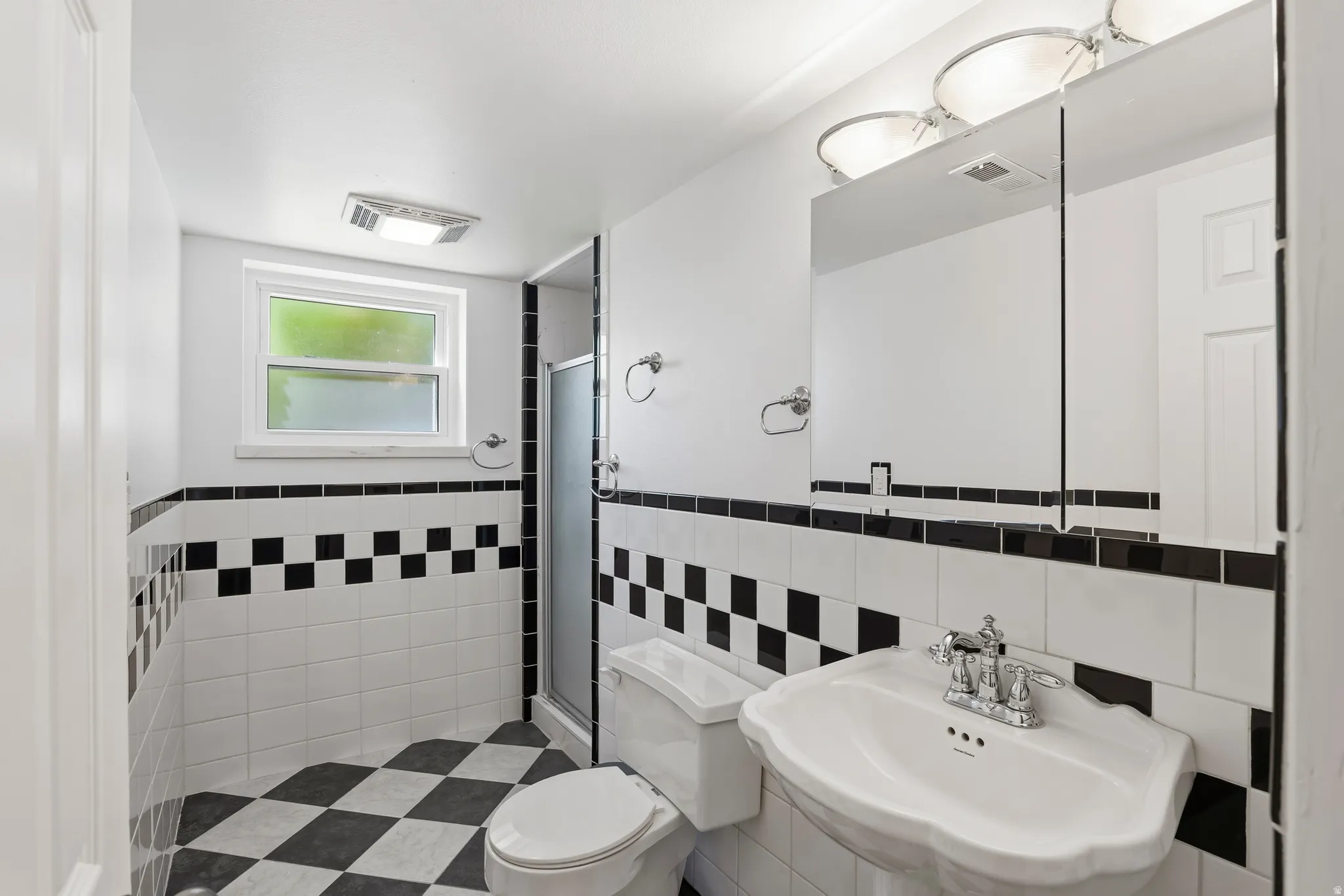 Black and white checkerboard flooring complemented by coordinating wall tiling