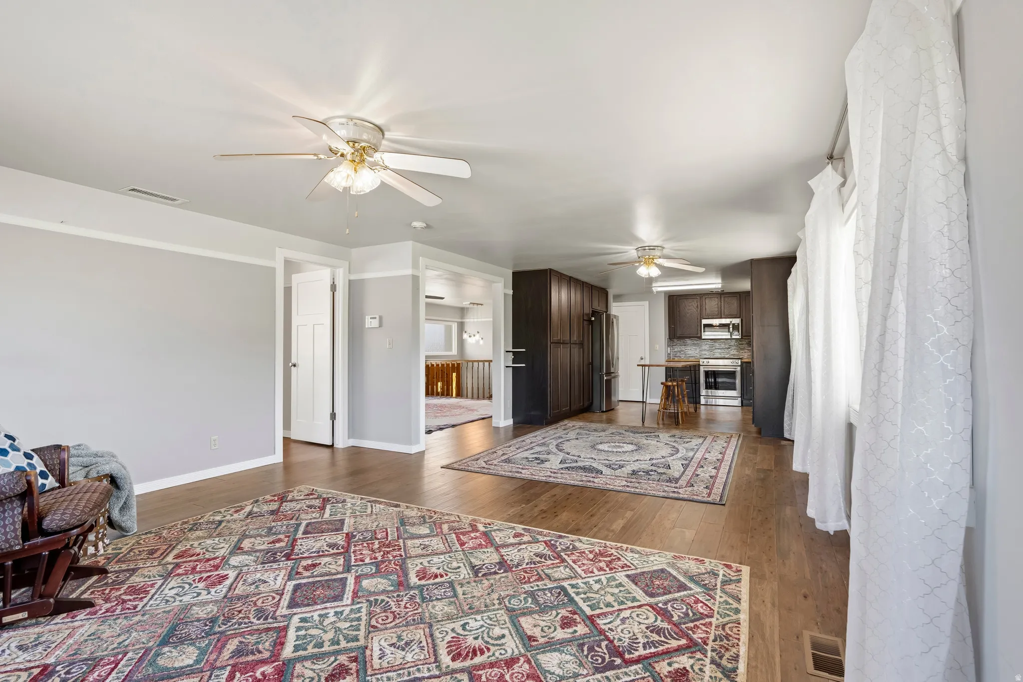 Open-concept living area featuring wood-finish flooring and light gray walls